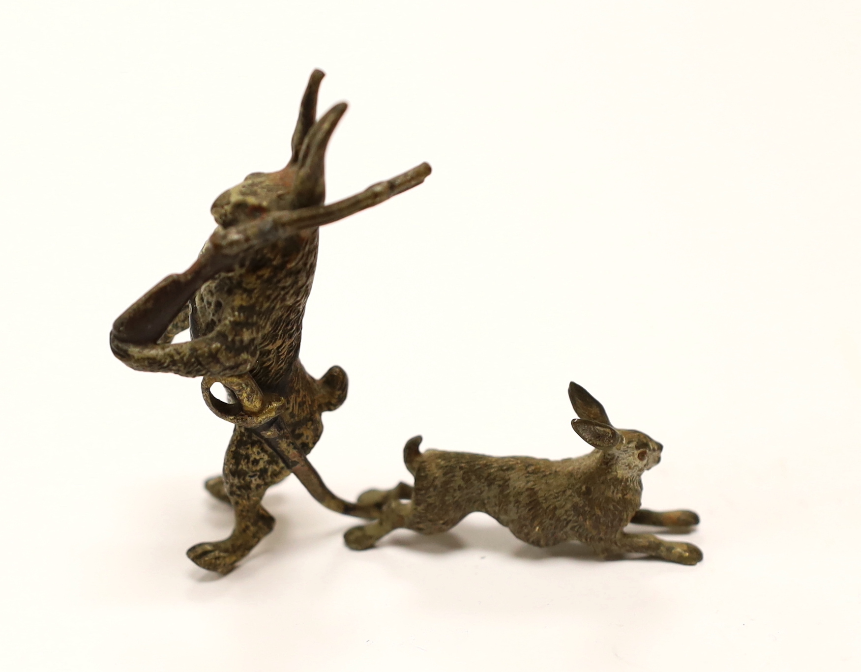 A novelty Austrian cold painted bronze model of a Hare with a rifle slung over its shoulder, 6.5cm, together with a similar smaller rabbit